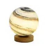 Modern table lamp with iron body and wood base illuminating a cozy bedroom