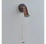 Walnut bedside wall light with adjustable spotlight and zipper switch in a cozy bedroom