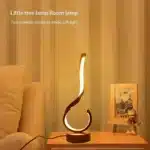 Modern desk lamp with adjustable arm and USB cable, glowing warmly on a wooden desk