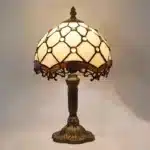 Vintage table lamp with handmade colored glass shade casting warm ambient light