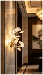 Luxury gold leaf sconce with modern ginkgo design illuminating a living room wall