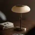 White glass table lamp with vintage design on a wooden desk in a cozy bedroom