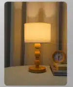 Vintage table lamp with fabric shade and solid wood base on bedside table