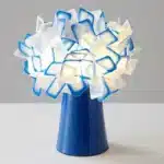 Modern table lamp with PVC flower design in a cozy bedroom setting