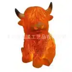 Whimsical cow table lamp with highland cattle design, casting a warm glow on a bedside table