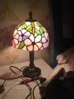 Vintage table lamp with handmade colored glass shade casting warm ambient light