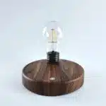 Floating LED lamp with levitating bulb on a wooden desk in a modern living room