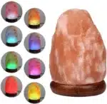 Salt lamp with color changing on wooden base glowing in warm light