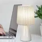 Milkshake bedside table lamp with warm LED light on a nightstand in a cozy bedroom