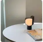 Rotating petal desk lamp with adjustable petals in pastel colors on a bedside table
