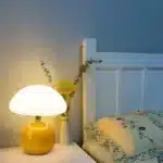 Mushroom table lamp with cream ceramic shade on bedside table