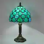 Vintage table lamp with handmade colored glass shade casting warm ambient light