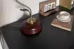 Vintage desk lamp with stained glass butterfly shade casting warm glow on bedside table