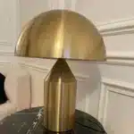 Modern mushroom table lamp with metal shade and wood base on bedside table