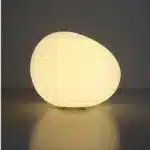 Modern table lamp with warm glow on bedside table