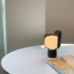 Rotating petal desk lamp with adjustable petals in pastel colors on a bedside table