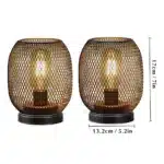 Battery table lamp with metal cage and warm LED glow on a wooden table