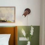 Walnut bedside wall light with adjustable spotlight and zipper switch in a cozy bedroom