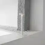Modern rechargeable table lamp glowing warmly on a wooden bedside table