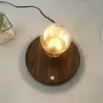 Floating LED lamp with levitating bulb on a wooden desk in a modern living room