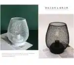 Decorative bird cage lamp with warm LED light, iron frame, and silk screen details on a bedside table