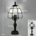 Tiffany table lamp with colorful stained glass shade casting warm glow on nightstand