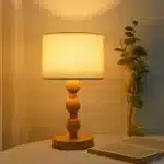 Vintage table lamp with fabric shade and solid wood base on bedside table