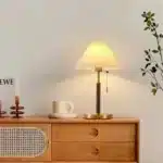 Retro desk lamp with black metal base and pleated fabric shade in warm glow