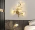 Luxury gold leaf sconce with modern ginkgo design illuminating a living room wall