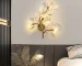 Luxury gold leaf sconce with modern ginkgo design illuminating a living room wall