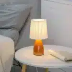 Milkshake bedside table lamp with warm LED light on a nightstand in a cozy bedroom