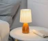 Milkshake bedside table lamp with warm LED light on a nightstand in a cozy bedroom