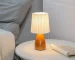 Milkshake bedside table lamp with warm LED light on a nightstand in a cozy bedroom