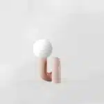 Modern glass table lamp with spherical shade on a wooden nightstand in a cozy bedroom