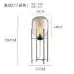 Modern floor lamp with iron frame and glass shade in a cozy living room