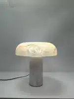 Elegant marble table lamp with soft glow on bedside table in bedroom
