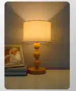 Vintage table lamp with fabric shade and solid wood base on bedside table