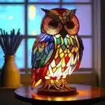 Colorful stained glass animal lamp featuring a cat design, glowing warmly on a bedside table