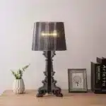 Modern acrylic table lamp glowing softly on a bedside table in a contemporary bedroom