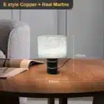 Elegant marble table lamp with soft glow on bedside table in bedroom