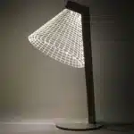 3D LED table lamp with wooden base and acrylic art glowing in a cozy room