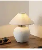 Wabi sabi table lamp with textured ceramic base and linen shade in a cozy living room