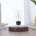 Floating LED lamp with levitating bulb on a wooden desk in a modern living room