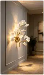 Luxury gold leaf sconce with modern ginkgo design illuminating a living room wall