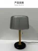 Modern bedside lamp with cream glass shade on a nightstand