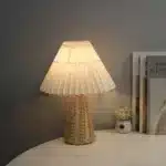 Handmade rattan bedside lamp with pleated shade on vintage nightstand