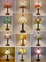 Vintage table lamp with handmade colored glass shade casting warm ambient light
