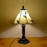 Vintage table lamp with handmade colored glass shade casting warm ambient light