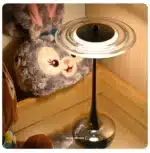 Goldoma rechargeable table lamp with flying saucer shape and warm glow on a bedside table