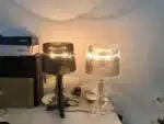 White ghost table lamp with transparent baroque design on a bedside table in a modern bedroom